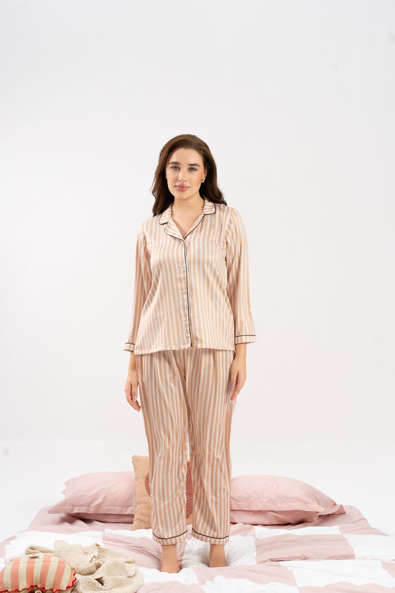 Woman wearing a striped pajama set on a white background