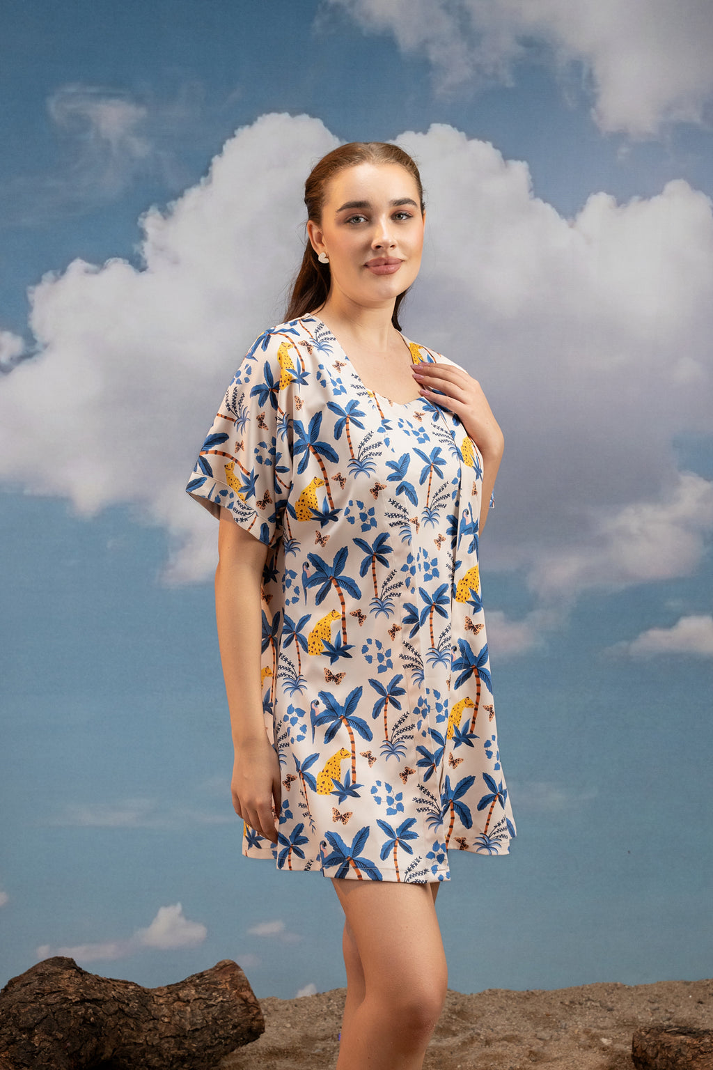 Woman wearing a floral dress against a blue sky with clouds